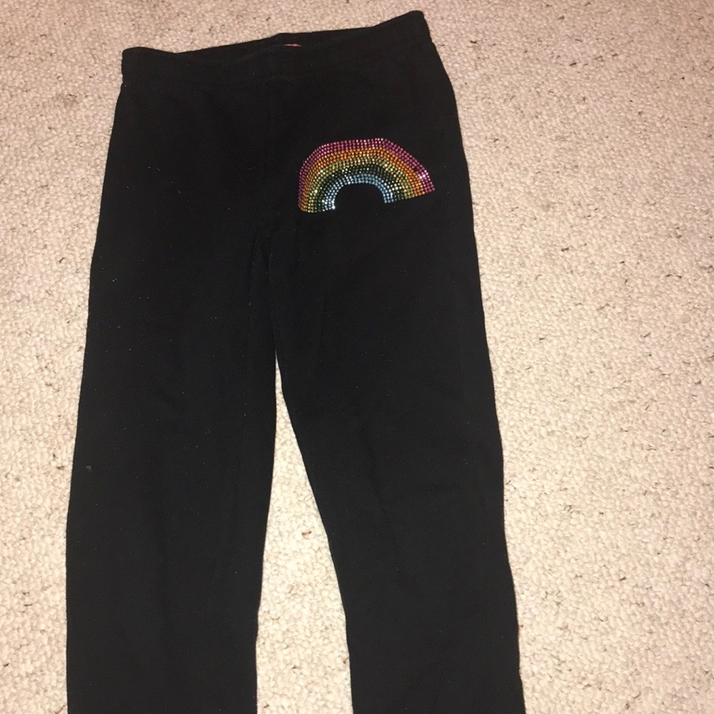 Sweatpants with a bedazzled rainbow on the front.